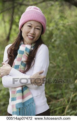 Woman outdoors wearing hat and scarf hugging herself, cold View Large Photo Image Stock Image - Woman outdoors wearing hat and scarf hugging herself, cold. Fotosearch