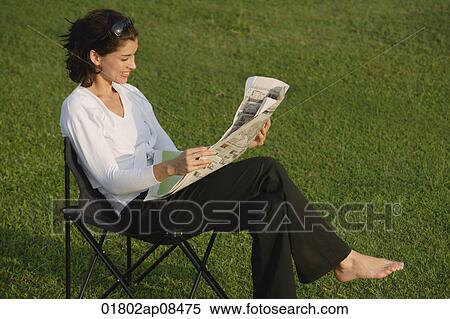 Woman reading newspaper in the park View Large Photo Image Stock Photography - Woman reading newspaper in the park. Fotosearch