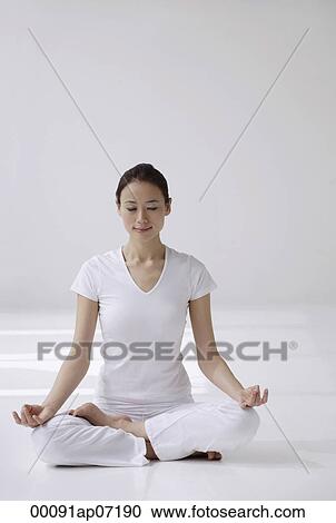 Woman sitting cross legged on floor, meditating, eyes closed View Large Photo Image Stock Image - Woman sitting cross legged on floor, meditating, eyes closed. Fotosearch