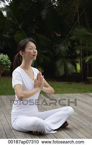 Woman sitting on porch, in tropical setting. legs crossed, hands in namaste, yoga posture. eyes closed View Large Photo Image Stock Image - Woman sitting on porch, in tropical setting. legs crossed, hands in namaste, yoga posture. eyes closed. Fotosearch