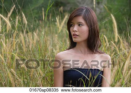 Woman standing in long grass View Large Photo Image Stock Photography - Woman standing in long grass. Fotosearch