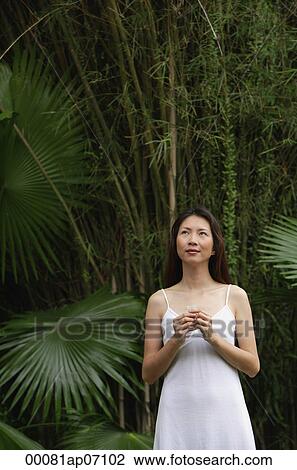 Woman standing outdoors, looking up, hands clasped View Large Photo Image Stock Image - Woman standing outdoors, looking up, hands clasped. Fotosearch