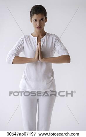 Woman standing with hands in namaste, prayer, looking at camera View Large Photo Image Stock Photo - Woman standing with hands in namaste, prayer, looking at camera. Fotosearch