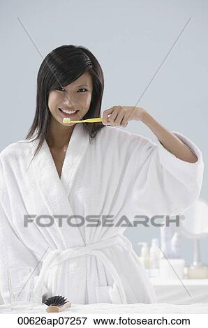 woman wearing bathrobe, brushing teeth in bathroom View Large Photo Image Stock Photo - woman wearing bathrobe, brushing teeth in bathroom. Fotosearch