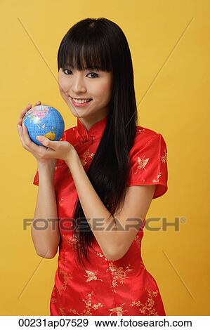 Woman wearing cheongsam and holding globe in hands View Large Photo Image Stock Photo - Woman wearing cheongsam and holding globe in hands. Fotosearch