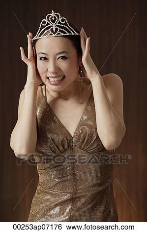 woman wearing crown, holding crown on head, smiling View Large Photo Image Stock Photograph - woman wearing crown, holding crown on head, smiling. Fotosearch