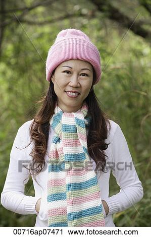 Woman wearing hat and scarf outdoors in nature, smiling at camera View Large Photo Image Stock Image - Woman wearing hat and scarf outdoors in nature, smiling at camera. Fotosearch