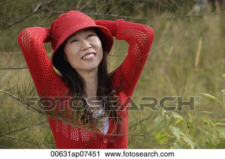 Woman wearing red hat outdoors in nature, smiling View Large Photo Image Stock Image - Woman wearing red hat outdoors in nature, smiling. Fotosearch