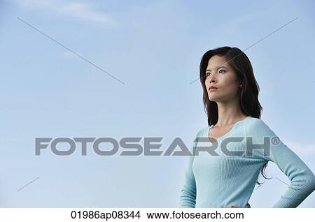 Woman with hands on hips looking into the distance View Large Photo Image Picture - Woman with hands on hips looking into the distance. Fotosearch