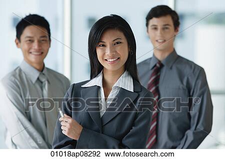 Work colleagues smile at the camera together View Large Photo Image Stock Image - Work colleagues smile at the camera together. Fotosearch