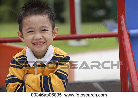 Young boy in striped shirt, smiling at camera View Large Photo Image Stock Photography - Young boy in striped shirt, smiling at camera. Fotosearch