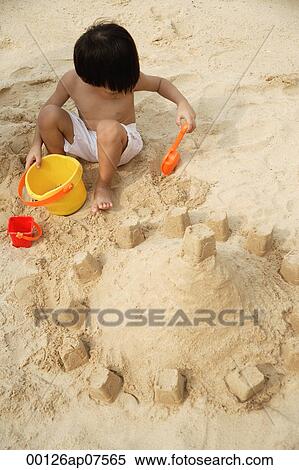 Young boy on beach building sand castle View Large Photo Image Stock Photography - Young boy on beach building sand castle. Fotosearch