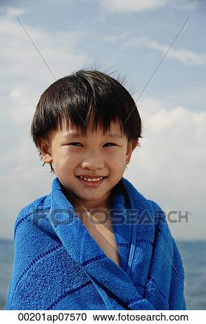 Young boy on beach wrapped in blue towel View Large Photo Image Stock Image - Young boy on beach wrapped in blue towel. Fotosearch