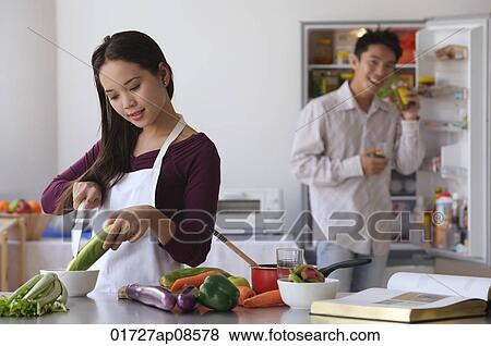 Stock Photo - Young couple cooking in the kitchen. Fotosearch