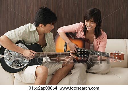 Young couple playing guitar View Large Photo Image Picture - Young couple playing guitar. Fotosearch