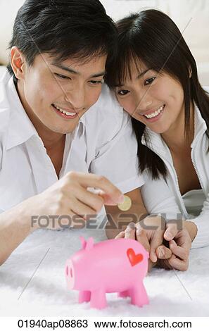 Young couple with piggy bank View Large Photo Image Stock Image - Young couple with piggy bank. Fotosearch