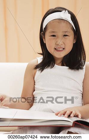 young girl, child, reading book, looking at camera, smiling View Large Photo Image Picture - young girl, child, reading book, looking at camera, smiling. Fotosearch