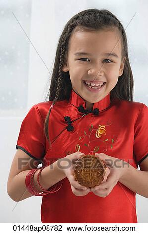Young girl in traditional Chinese dress holding cookie and smiling at camera View Large Photo Image Stock Image - Young girl in traditional Chinese dress holding cookie and smiling at camera. Fotosearch