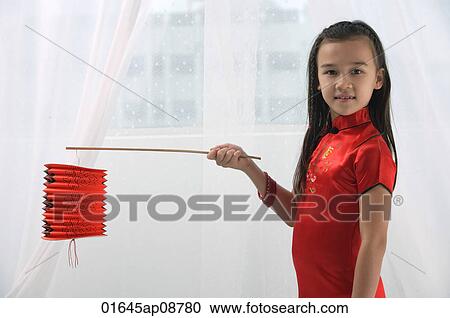 Young girl in traditional Chinese dress holding red lantern and looking at camera View Large Photo Image Stock Image - Young girl in traditional Chinese dress holding red lantern and looking at camera. Fotosearch