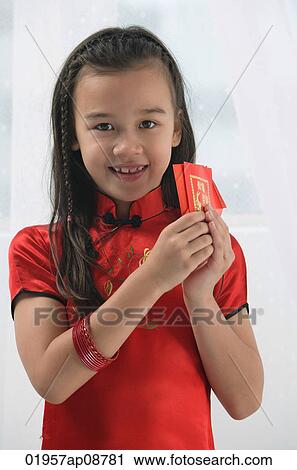 Stock Image - Young girl in traditional Chinese dress and looking at camera. Fotosearch