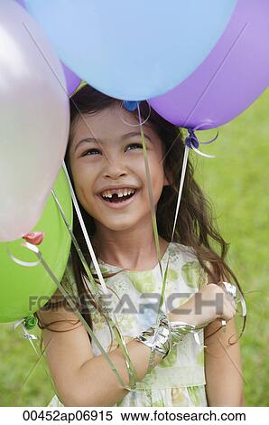 Stock Photography - Young girl with several balloons, smiling. Fotosearch
