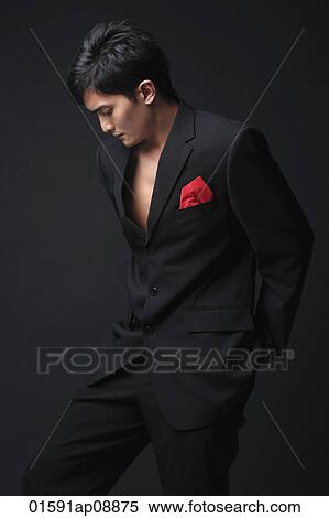 Young man in black suit looking down View Large Photo Image Stock Photography - Young man in black suit looking down. Fotosearch