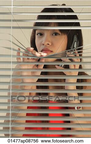 Young woman behind Venetian blinds View Large Photo Image Stock Photograph - Young woman behind Venetian blinds. Fotosearch