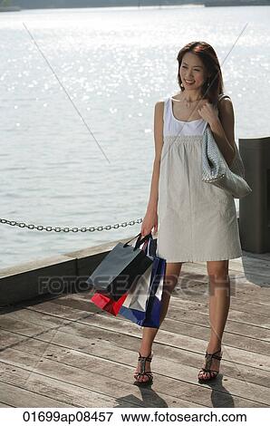 Young woman carrying shopping bags View Large Photo Image Stock Photo - Young woman carrying shopping bags. Fotosearch