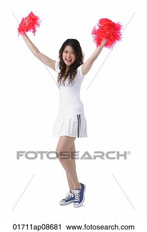 Stock Image - Young woman cheerleading with pom poms. Fotosearch