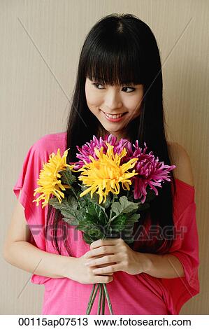Young woman holding bouquet of flowers View Large Photo Image Stock Image - Young woman holding bouquet of flowers. Fotosearch