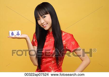 Young woman holding chinese dice meaning "east & west" View Large Photo Image Picture - Young woman holding chinese dice meaning "east & west". Fotosearch