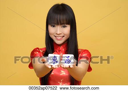 Young woman holding Chinese dice meaning "east & west" View Large Photo Image Stock Image - Young woman holding Chinese dice meaning "east & west". Fotosearch