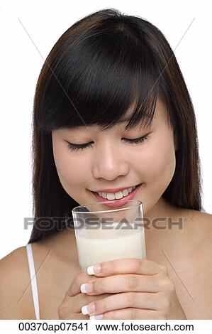Young woman holding glass of milk, eyes closed View Large Photo Image Stock Image - Young woman holding glass of milk, eyes closed. Fotosearch