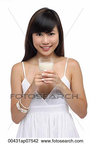 Young woman holding glass of milk, smiling View Large Photo Image Stock Image - Young woman holding glass of milk, smiling. Fotosearch