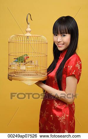 Young woman holding lovebird in bird cage, smiling View Large Photo Image Stock Photograph - Young woman holding lovebird in bird cage, smiling. Fotosearch