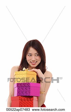 Young woman holding three presents, smiling View Large Photo Image Stock Image - Young woman holding three presents, smiling. Fotosearch