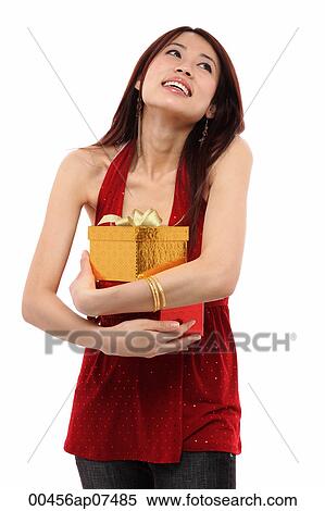 Stock Photography - Young woman holding two presents, looking up. Fotosearch