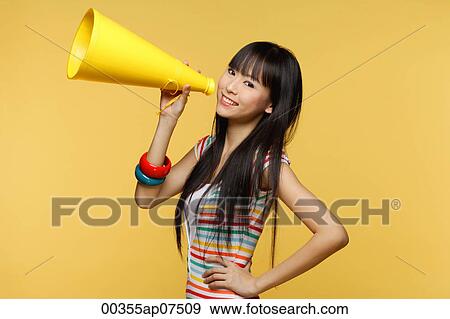 Young woman holding yellow megaphone and smiling at camera View Large Photo Image Stock Photo - Young woman holding yellow megaphone and smiling at camera. Fotosearch