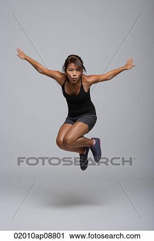 Young woman jumping up View Large Photo Image Stock Image - Young woman jumping up. Fotosearch