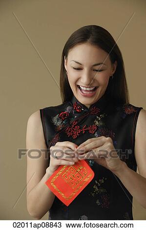 Young woman laughing while opening red envelope View Large Photo Image Stock Image - Young woman laughing while opening red envelope. Fotosearch