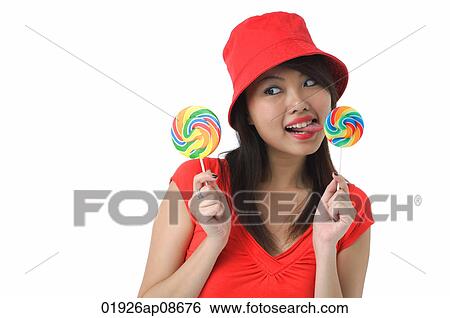 Stock Photograph - Young woman licking on lollipop. Fotosearch