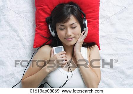 Young woman listening to music View Large Photo Image Stock Photo - Young woman listening to music. Fotosearch