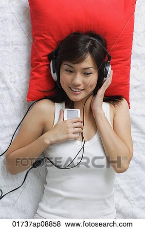 Young woman listening to music View Large Photo Image Stock Photo - Young woman listening to music. Fotosearch