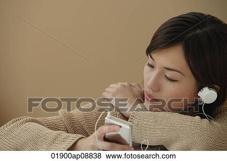 Young woman listening to music View Large Photo Image Stock Photo - Young woman listening to music. Fotosearch