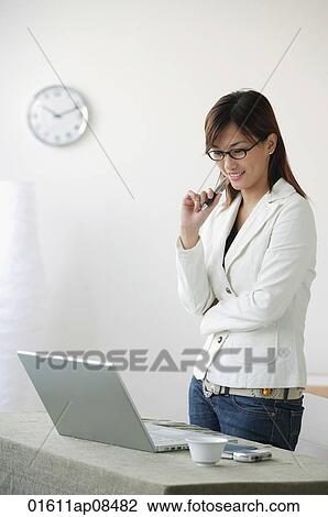 Young woman looking at laptop View Large Photo Image Stock Image - Young woman looking at laptop. Fotosearch
