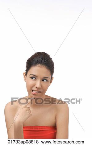 Stock Photo - Young woman looking sideways, thinking. Fotosearch