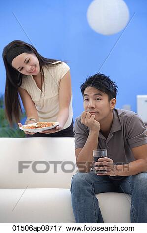 Young woman offering man a plate of food View Large Photo Image Stock Photo - Young woman offering man a plate of food. Fotosearch