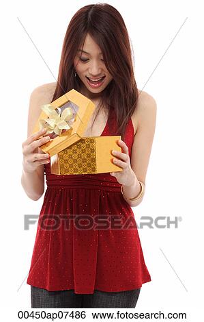 Young woman opening present and looking inside box View Large Photo Image Stock Photograph - Young woman opening present and looking inside box. Fotosearch