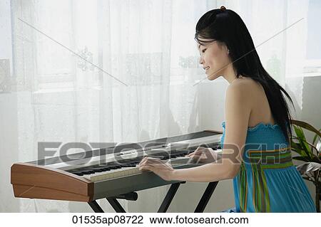Young woman playing keyboard View Large Photo Image Stock Image - Young woman playing keyboard. Fotosearch