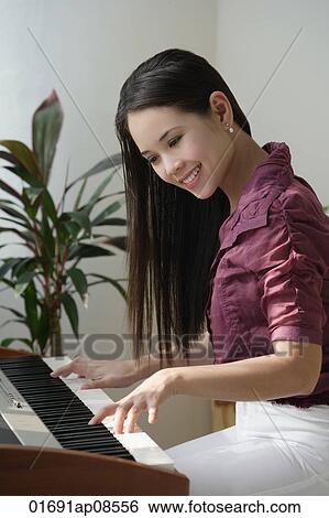 Young woman playing keyboard View Large Photo Image Stock Photograph - Young woman playing keyboard. Fotosearch